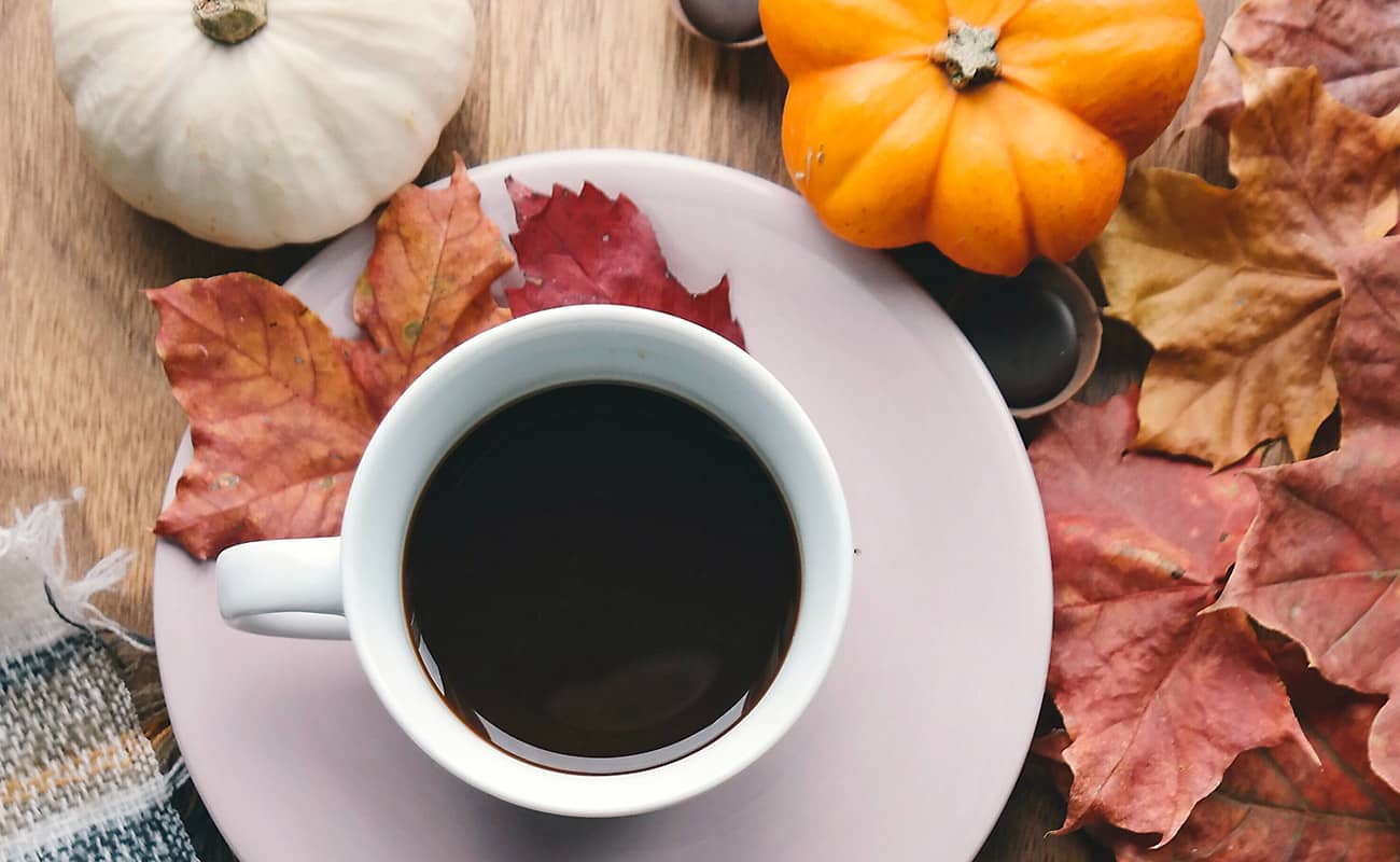 Cup of Black Coffee and Pumpkins with Maple Leaves